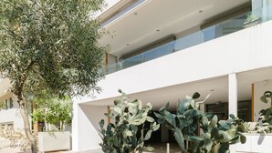 A modern building with a courtyard featuring potted cacti and a tree. - UPSTREET Modern 1BD Apt Acropolis Museum (Athens)