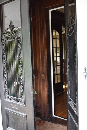 Une porte en bois avec un portail en métal et une fenêtre.