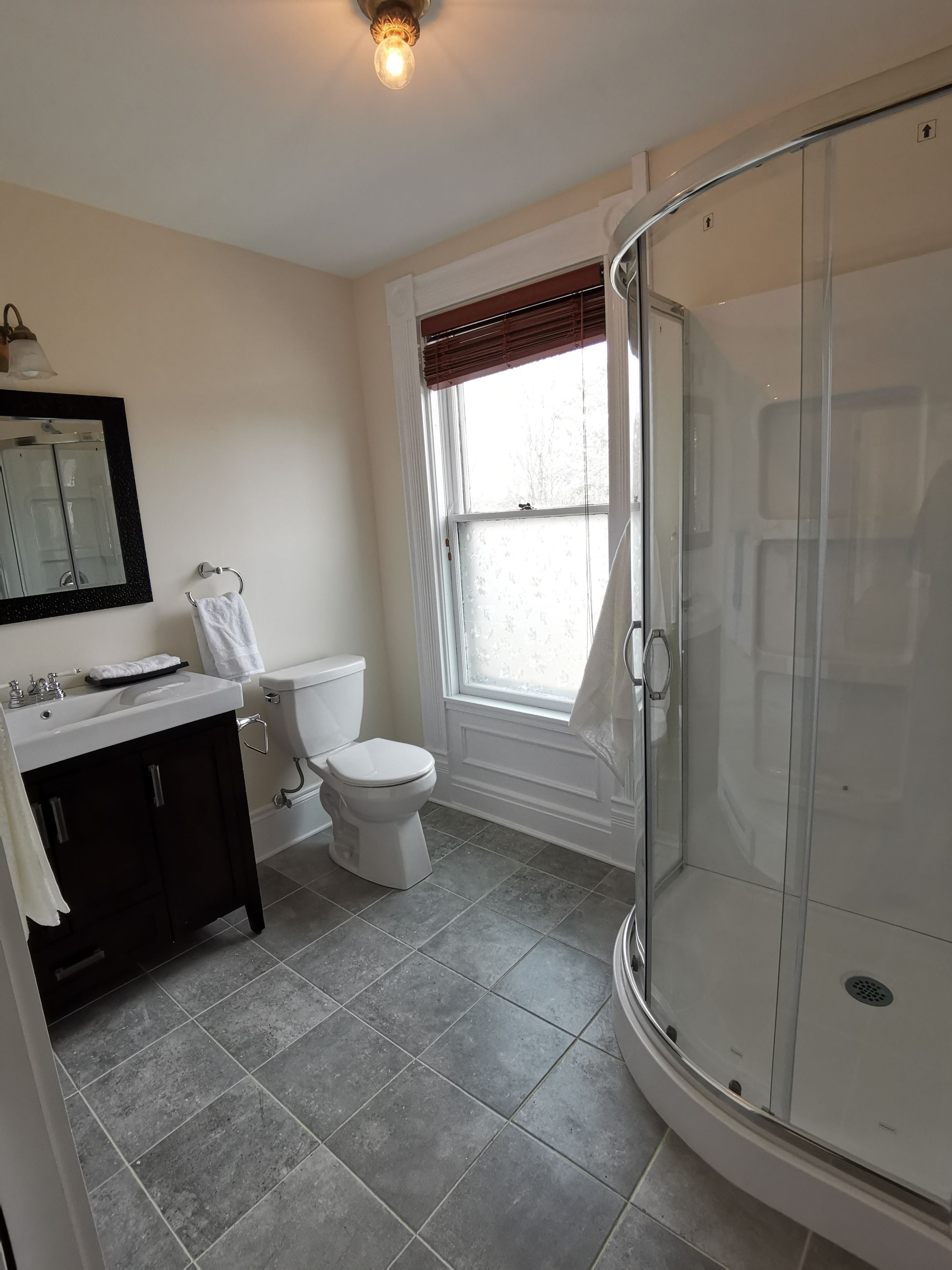 Une salle de bain avec des toilettes, un lavabo et une douche.
