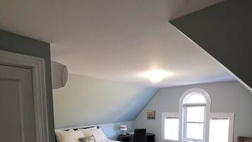 Een slaapkamer met een groot bed, een nachtkastje en een raam. De tekst 'Badkamer buiten de slaapkamer!' is zichtbaar.