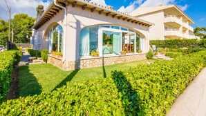 A modern house with a stone facade, large windows, and a well-maintained garden. - House Puerto Pollensa Llenaire with pool (Puerto Pollensa)