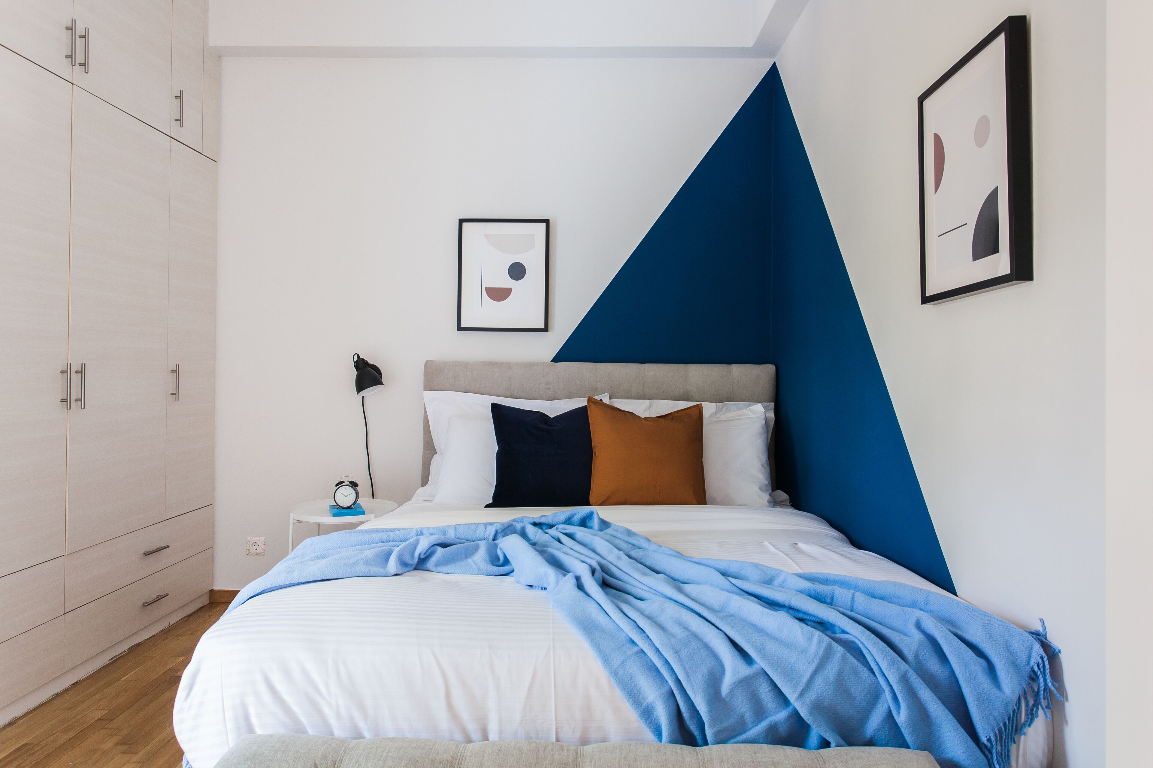 Una camera da letto con un letto, un comodino, una lampada e un armadio.