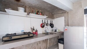 Une cuisine équipée d’une cuisinière à gaz, d’un évier et d’un réfrigérateur.