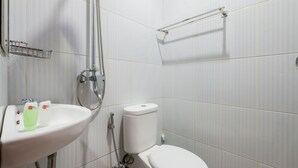 A bathroom with a white sink, toilet, and shower. - RedDoorz @ Kerta Dalem Sidakarya (Denpasar)