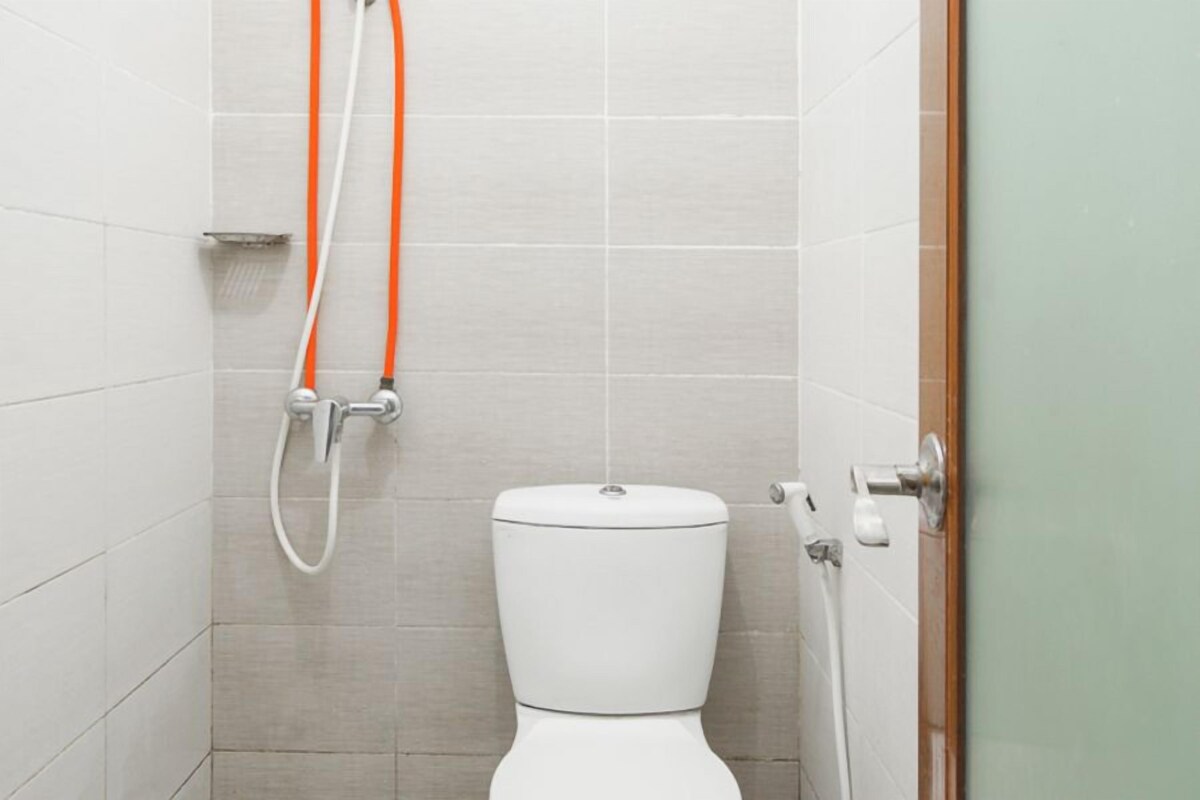 A small, clean bathroom with a toilet, a shower, and a door.