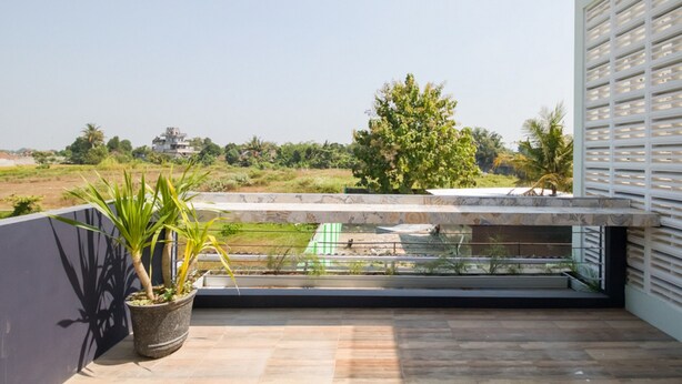 A balcony with a view of a green field and a tree. - RedDoorz near UMY Yogyakarta 3 (Sleman)