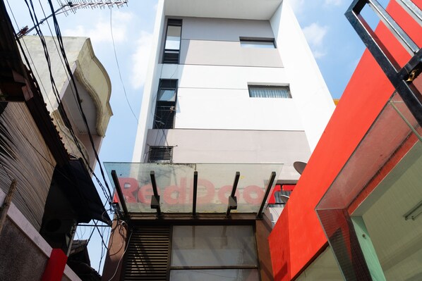 Un edificio de varios pisos con un diseño moderno, caracterizado por un llamativo esquema de color rojo y blanco.
