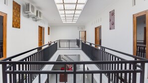 A modern interior with a central staircase, white walls, and a skylight. - RedDoorz near Pascasarjana UGM 2 (Pogung Lor)
