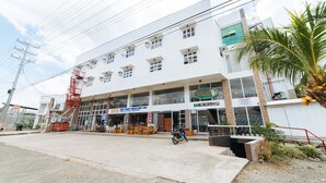 A multi-story building with a ground floor featuring a furniture store and a sign indicating a sale. - RedDoorz @ Lawaan Roxas City (Roxas City)