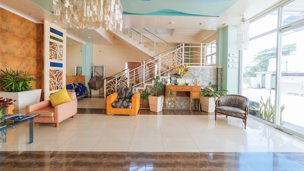 Um hall amplo com escada, área de estar e grandes janelas.