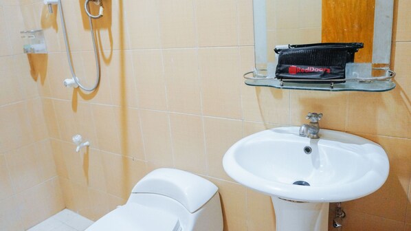 A bathroom with a white sink, a mirror, and a shower. - RedDoorz near Old Tagbilaran Airport (Tagbilaran)