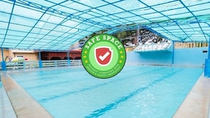 A swimming pool with a safety sign and a blue roof structure. - RedDoorz Premium @ Gabinete Road Palawan (Puerto Princesa)