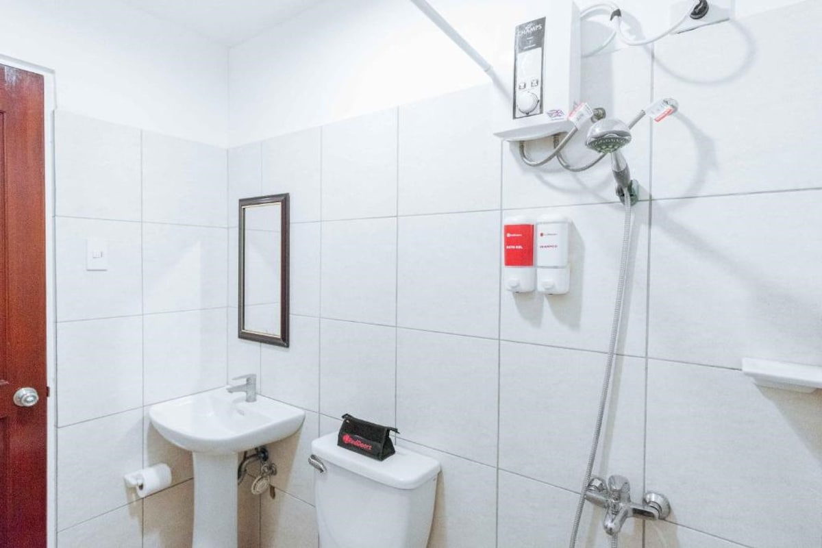 A bathroom with a white sink, toilet, and shower.
