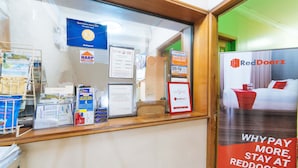 A reception desk with various informational posters, including a RedDoorz advertisement. - RedDoorz @ Clarkview 21st Street Angeles City (Angeles City)