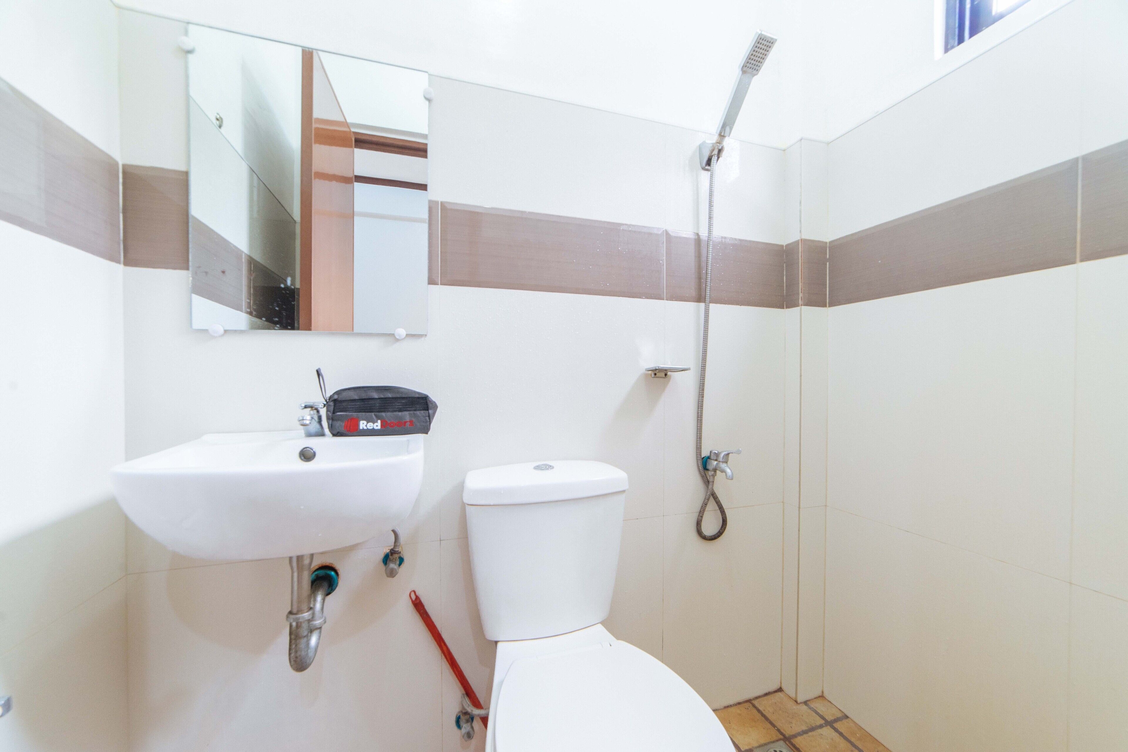 A bathroom with a white sink, toilet, and shower.