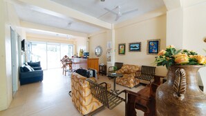 A spacious living area with a sofa, armchairs, a coffee table, and a decorative vase. - Reddoorz @ Old Buswang Road (Kalibo)