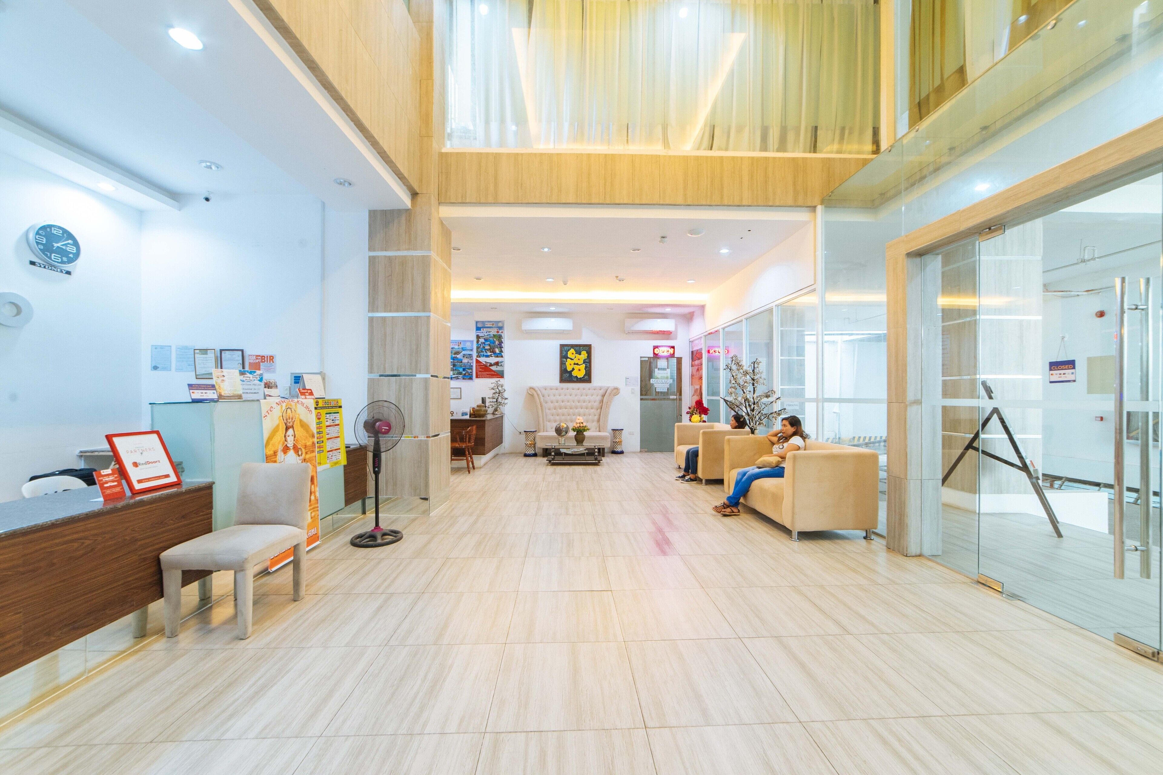A spacious lobby with a reception desk, seating area, and a glass wall.