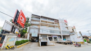Un immeuble à plusieurs étages, sur lequel on peut voir une grande enseigne rouge portant l'inscription « Citi Hardware ».