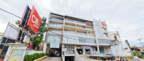 Un edificio de varios pisos con un letrero rojo llamativo que dice 'Citi Hardware'.