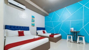 A hotel room with two beds, a blue geometric wall, a small table with stools, and an air conditioning unit. - RedDoorz @ Aparente Gensan (General Santos)