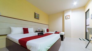 Een hotelkamer met een groot bed, een bureau en een stoel.