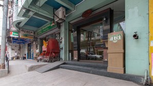 A hotel entrance with a large glass door, a visible staircase leading up to the entrance, and a sign for 'Hotel La Rica'. - RedDoorz @ Downtown Tacloban (Tacloban)