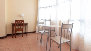 A small dining area with a wooden table and chairs, a water bottle, and a lamp. - RedDoorz @ Downtown Tacloban (Tacloban)