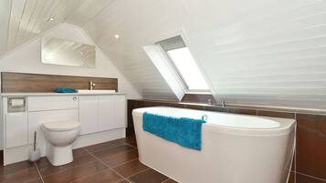 Bathtub, hair dryer, towels, toilet paper