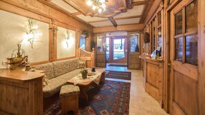 Un intérieur en bois avec un canapé, une table et des appliques murales décoratives.