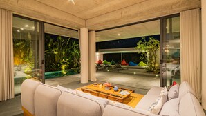 A modern living room with a sofa, a coffee table, and a view of the outdoor area. - Akala Villa,  Hoi An, Luxury 6 bedrooms, Superb Rivers View, Hoi An Ancient Town (Hội An)