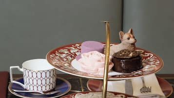 Uma mesa posta com louça fina, talheres e um cardápio.