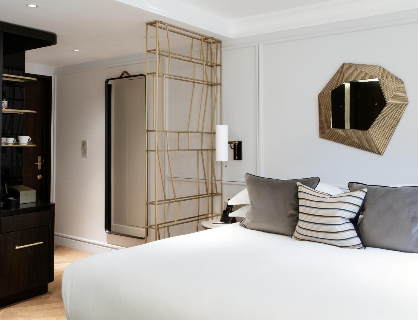Un dormitorio con cama, mesita de noche, lámpara y armario.