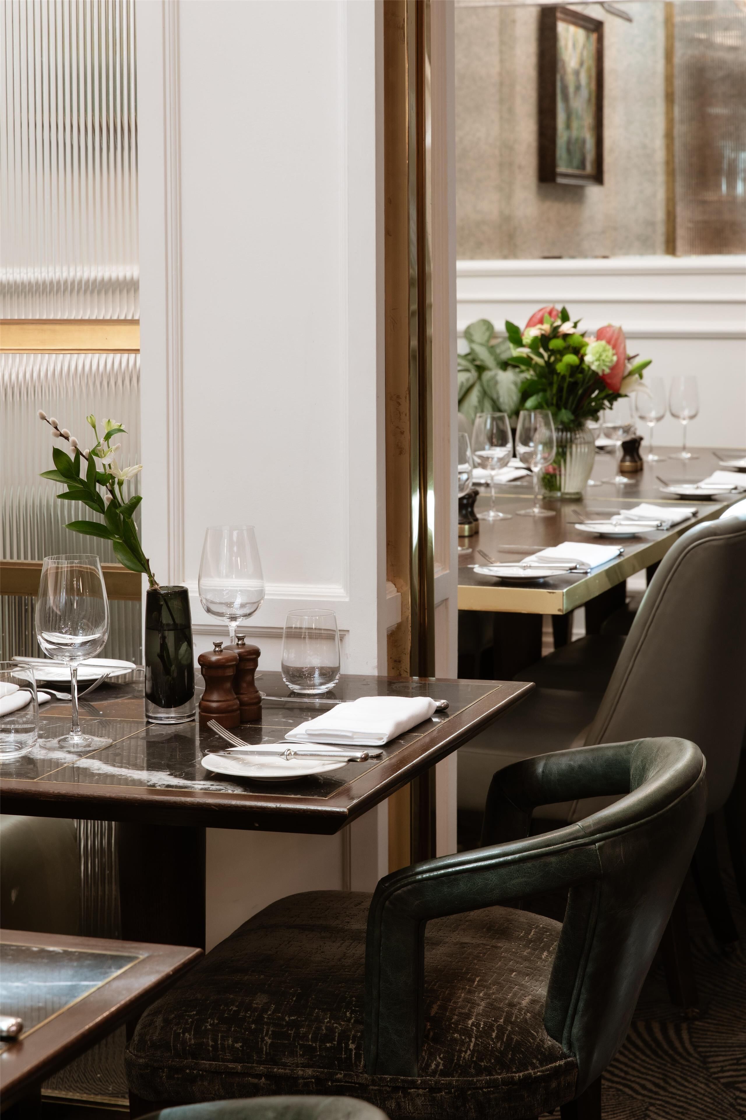A dining area with a table set for a meal, including plates, cutlery, and glasses.
