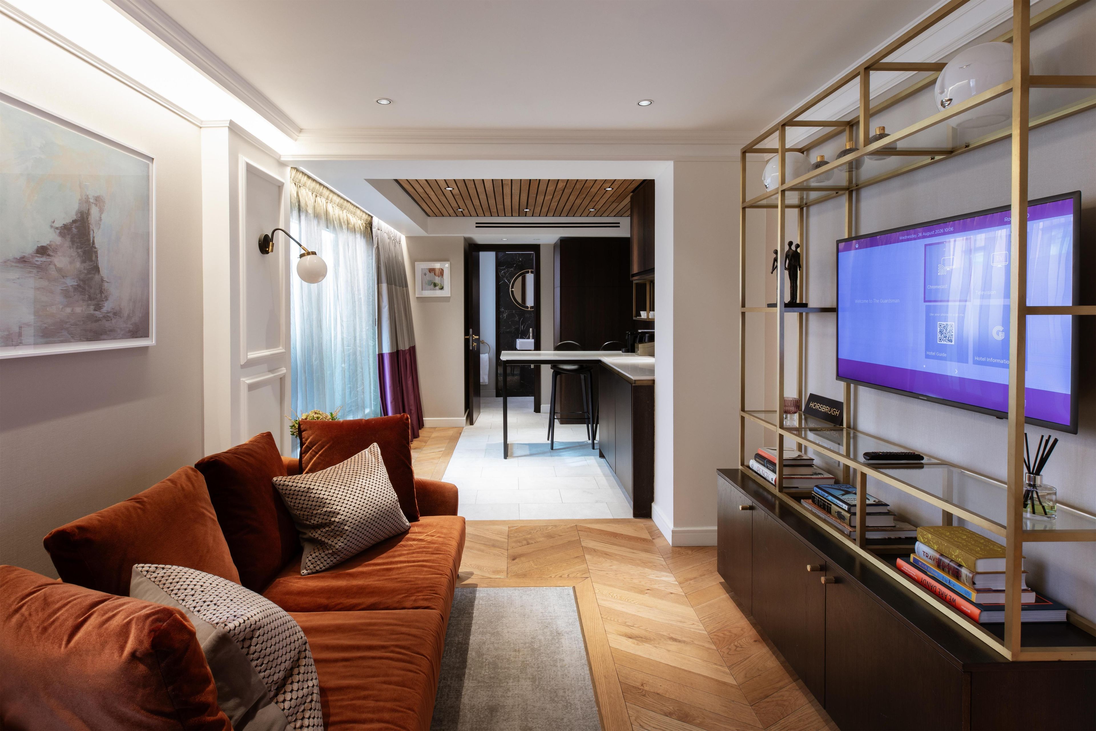 A modern living room with a sofa, a television, and a bookshelf.