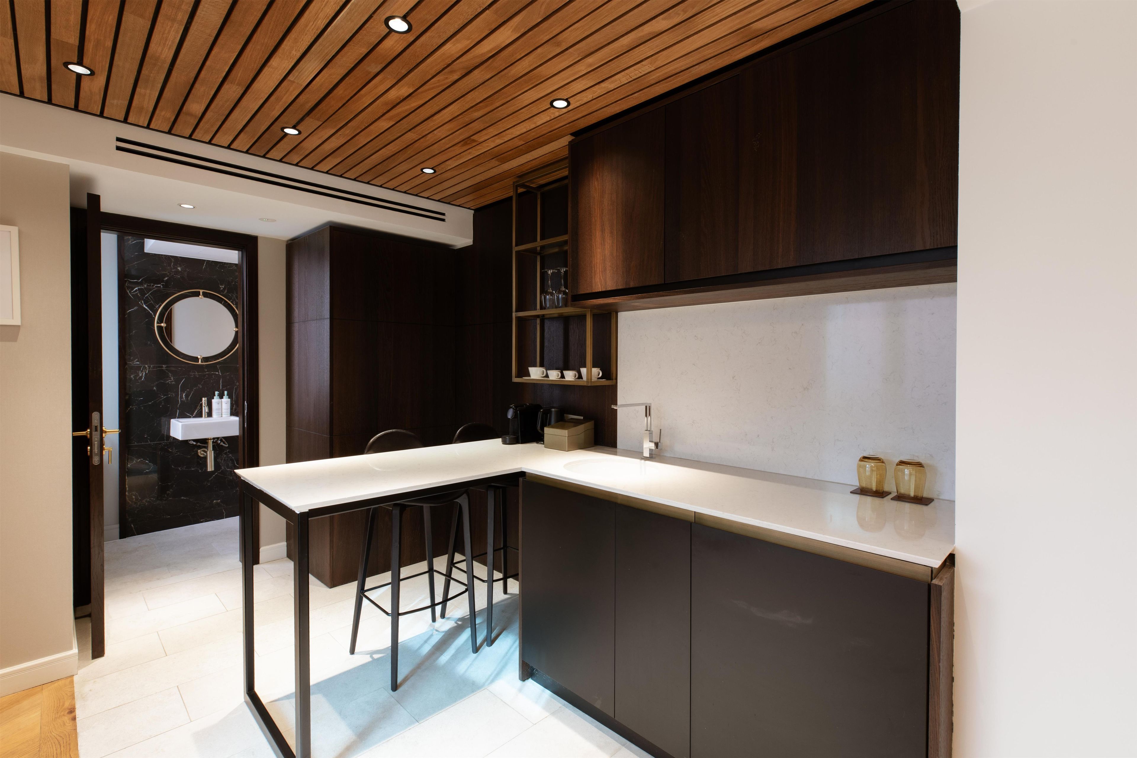 A modern kitchen with a central island, dark wood cabinets, and a marble backsplash.