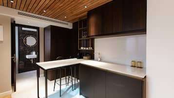A modern kitchen with a central island, dark wood cabinets, and a marble backsplash.