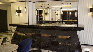 A modern bar area with a reflective surface, black chairs, and pendant lighting. - Emens Hotel (Izmir)