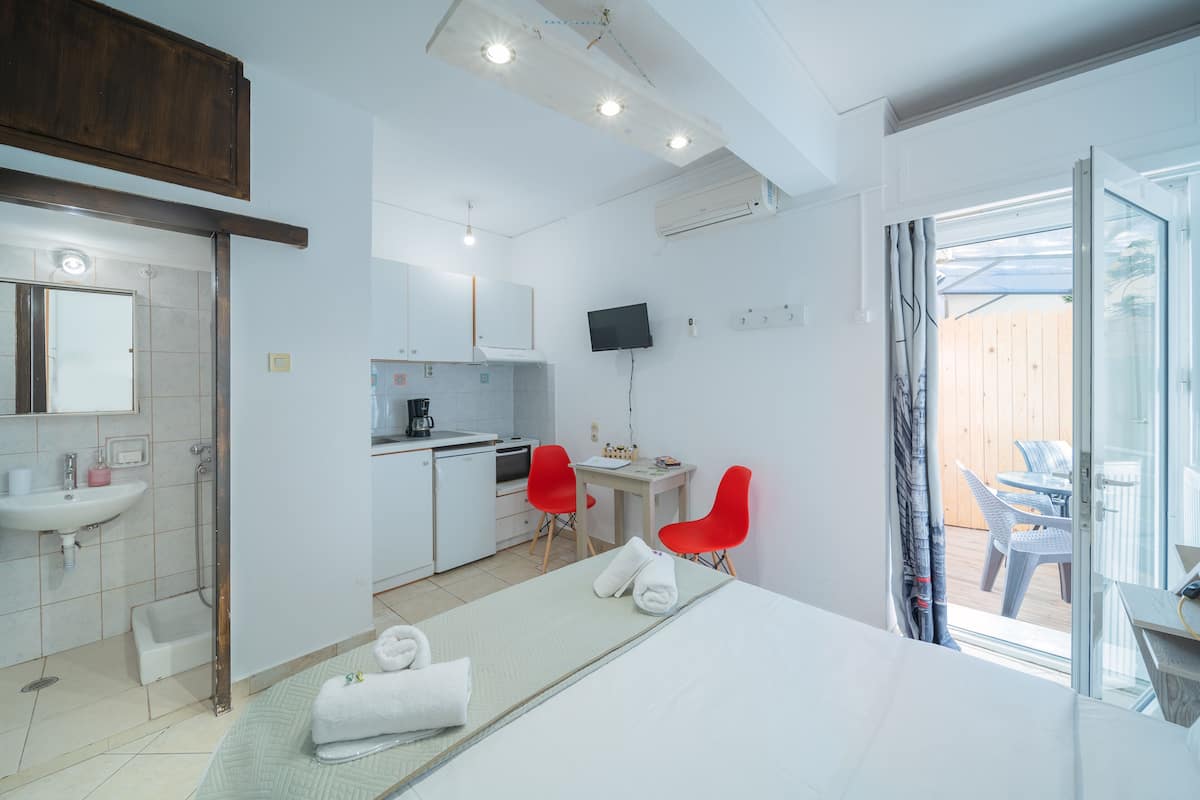 Une chambre d’hôtel moderne équipée d’un lit, d’un bureau, d’une chaise, d’un lavabo et d’une télévision.