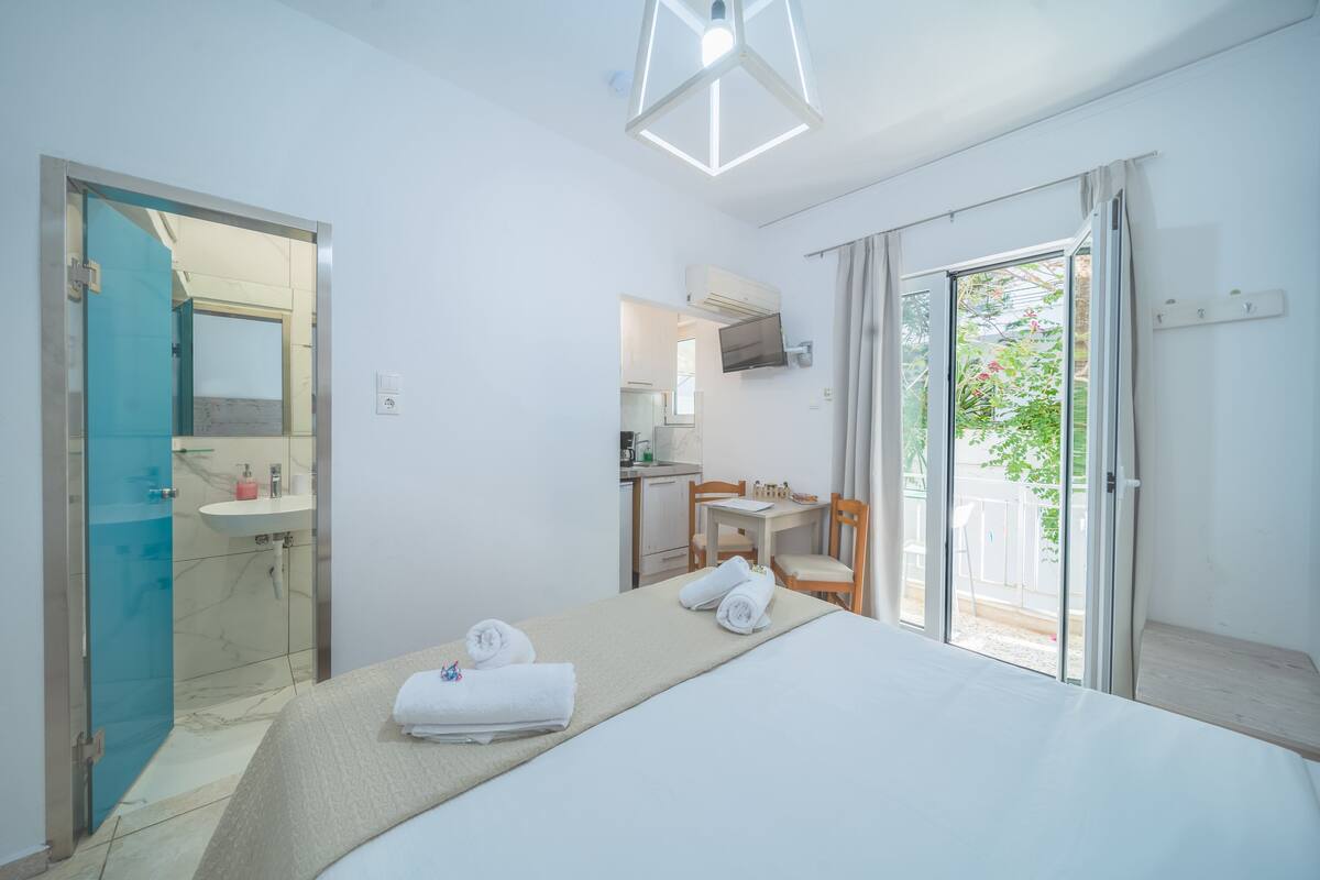 Une chambre d’hôtel comprenant un lit, une salle de bain, un petit coin cuisine et un balcon avec vue.