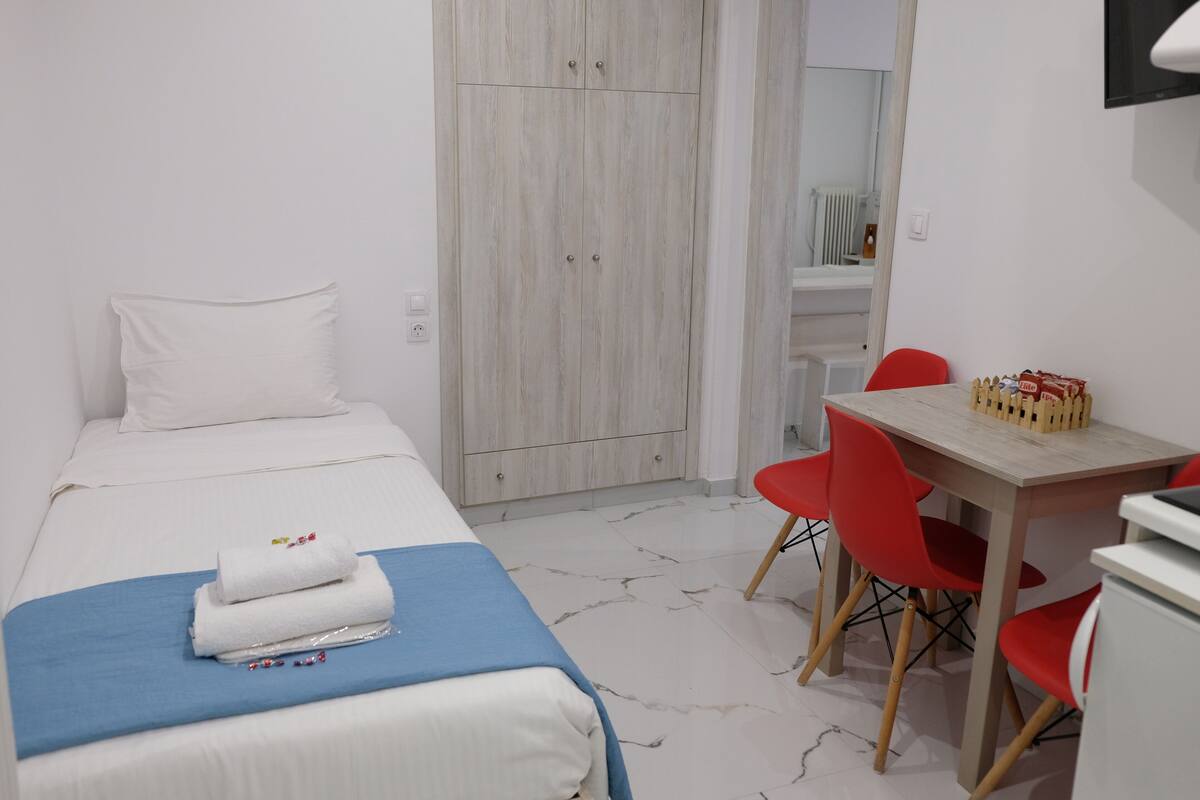 Une chambre d’hôtel avec un lit, un bureau et une chaise.