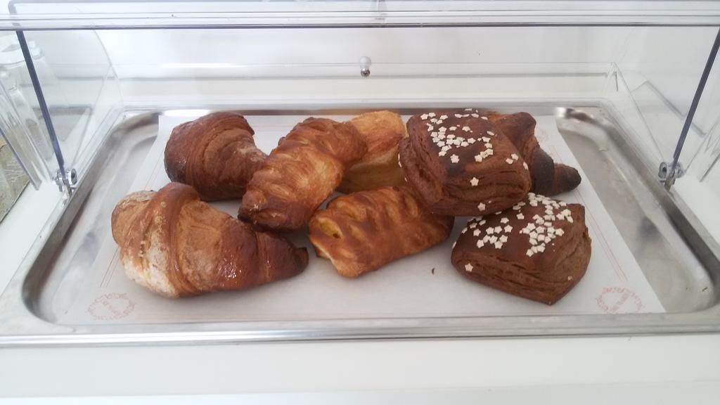 Una vetrina espositiva con diversi dolci, tra cui croissant e prodotti al cioccolato, in una pasticceria.