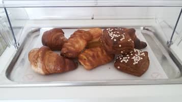 Una vetrina espositiva con diversi dolci, tra cui croissant e prodotti al cioccolato, in una pasticceria.