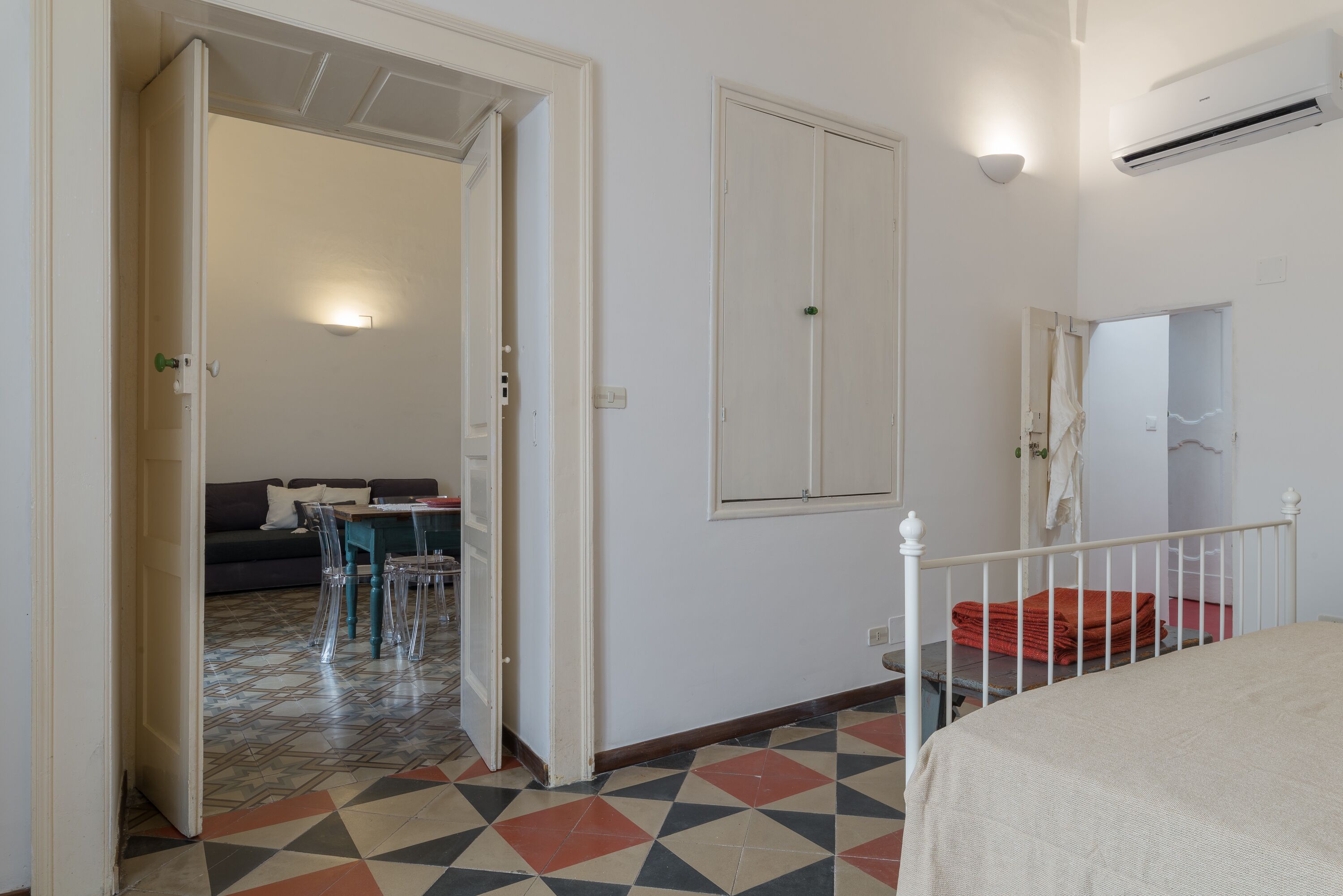 A room with a bed, a dining table with chairs, and a sofa.