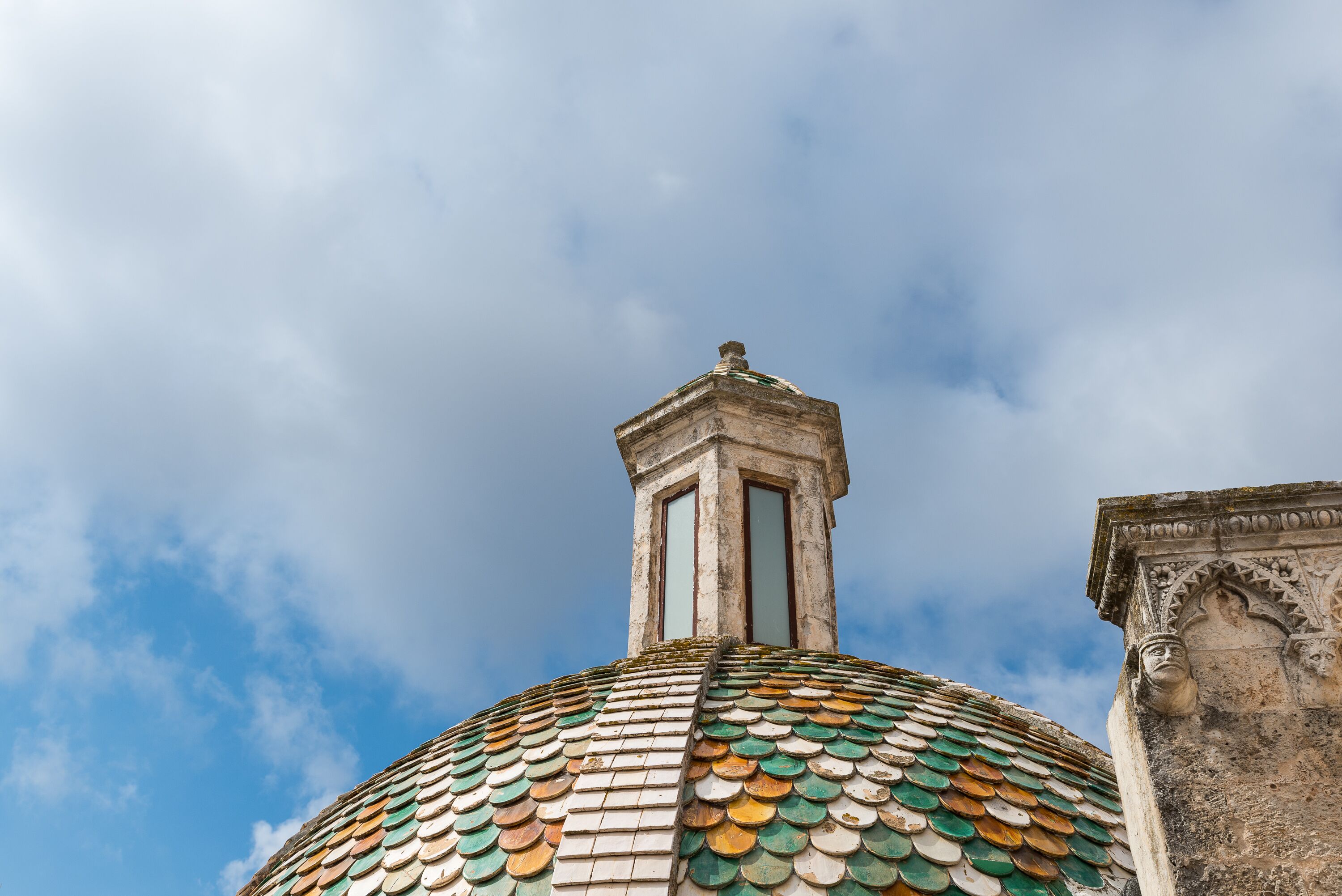 A dome with a tiled roof and a small tower.
