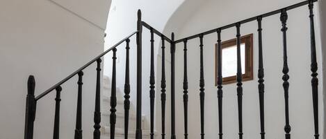 A staircase with black balusters and a wooden door at the top.
