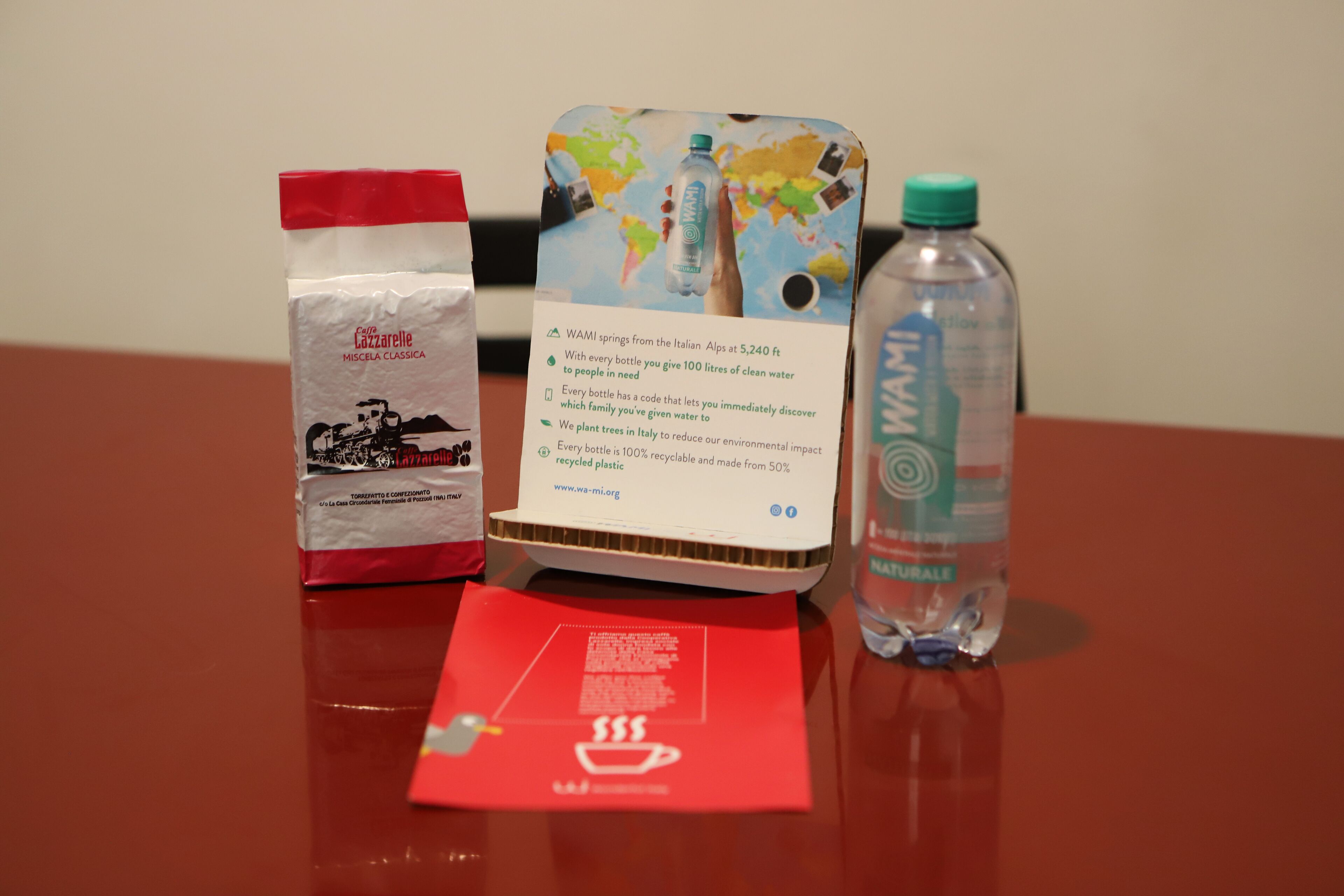 A table with a red bag, a booklet, and a water bottle.