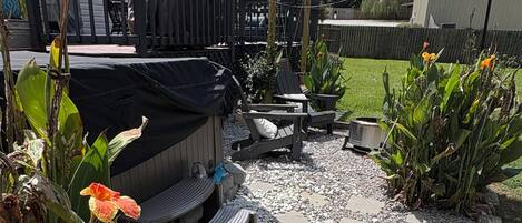 A patio area with a grill, seating, and a wooden deck.