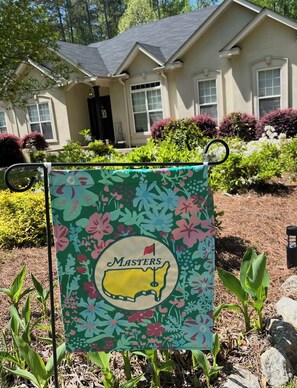 A house with a well-maintained garden and a flag on a flagpole. - 6 Bedroom - Wonderful, Private Masters Rental!! (Evans)