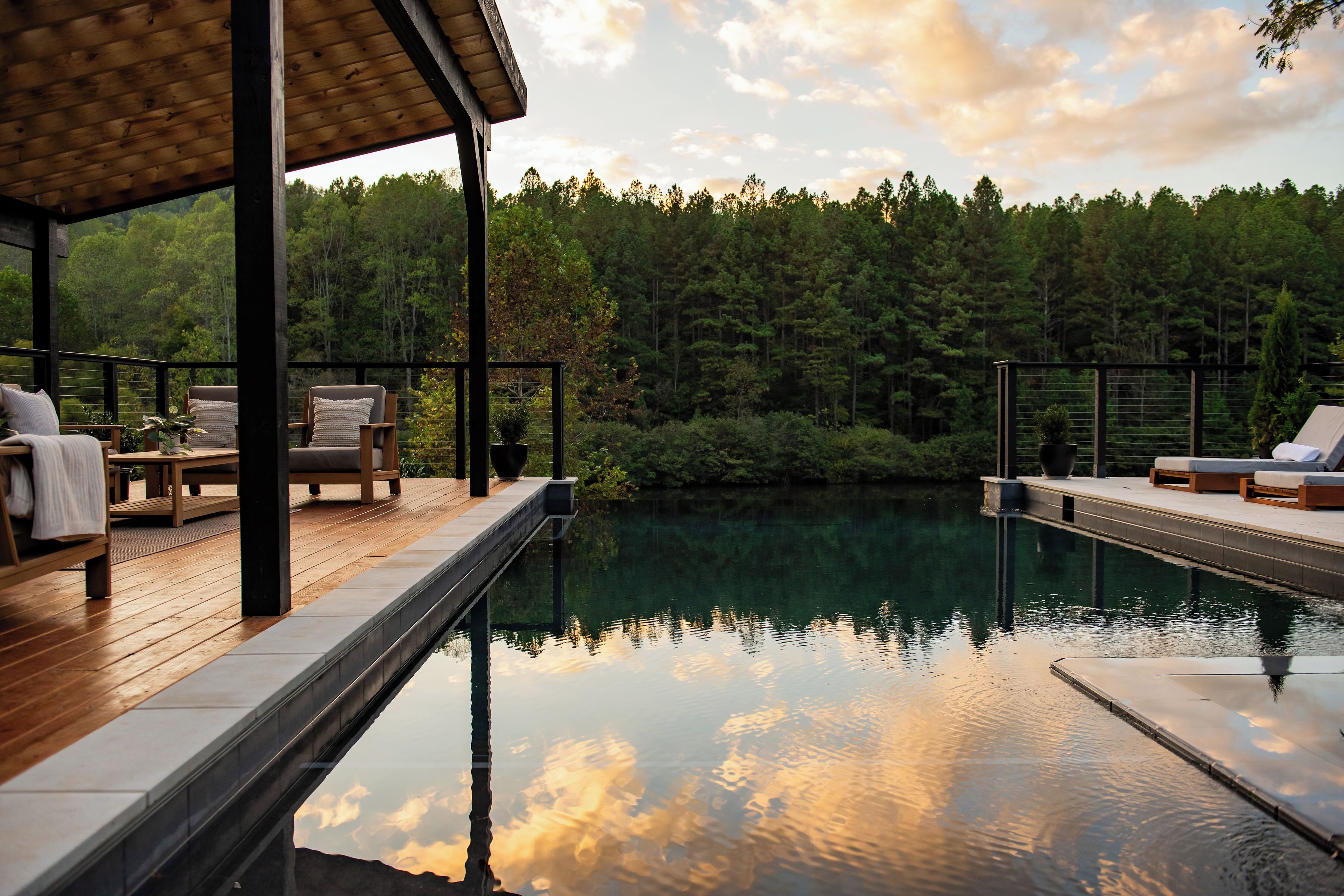 A wooden deck with lounge chairs and a swimming pool.