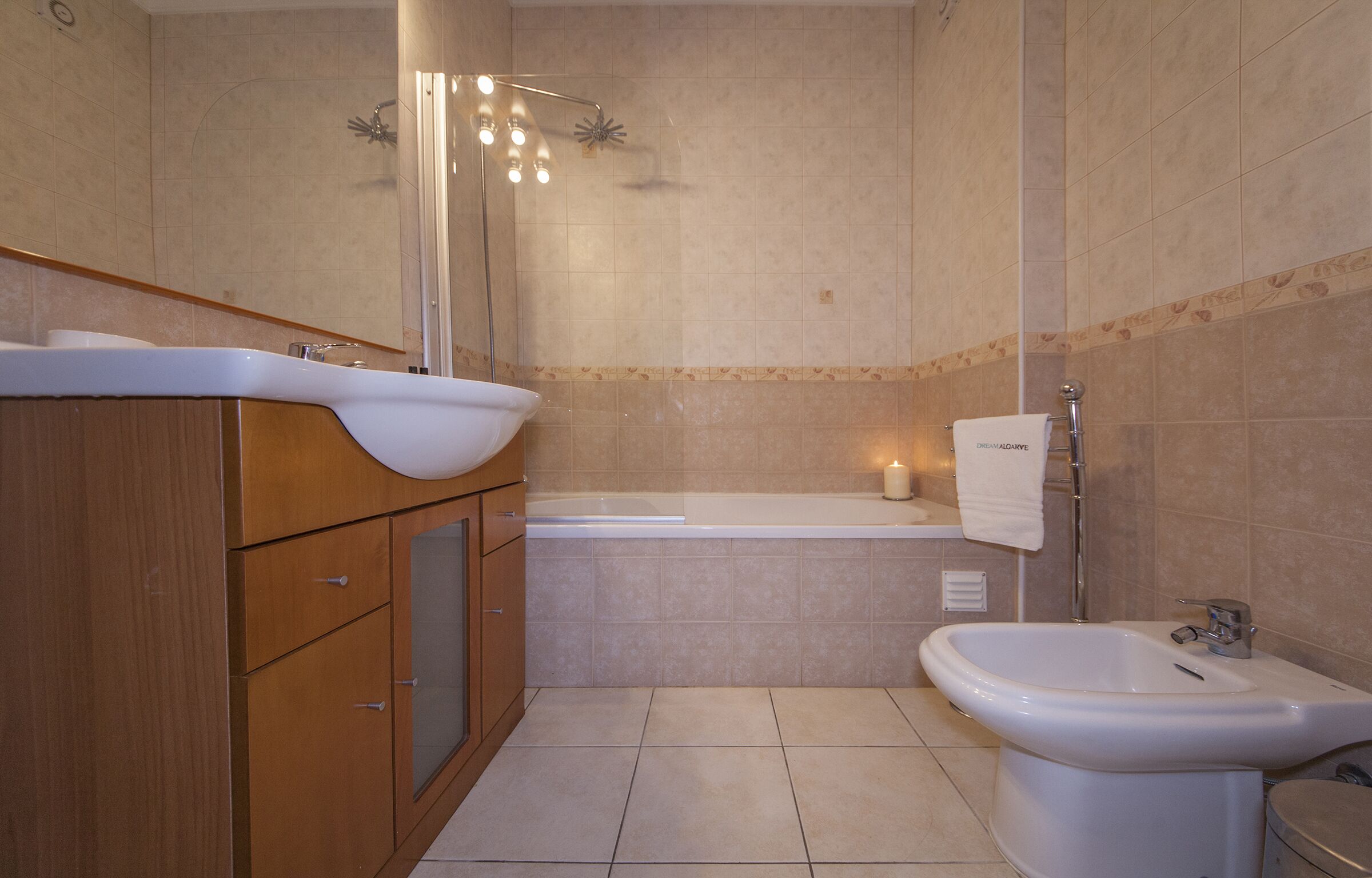 Un baño con bañera, bidé, lavabo y espejo.